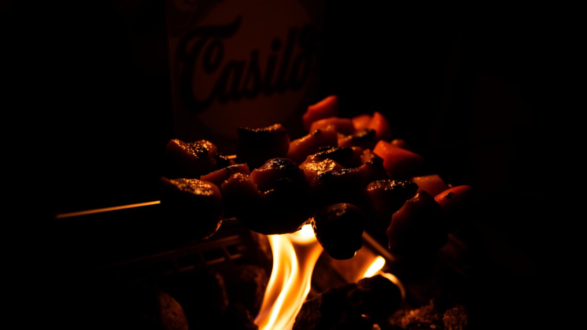 Sizzling kebab skewers grilling over open flame